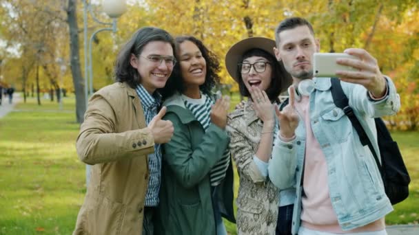 Riendo jóvenes amigos tomando selfie en el parque con la cámara del teléfono inteligente — Vídeos de Stock