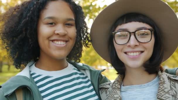 Close-up portrait of attractive ladies Afro-American and Caucasian smiling outdoors — 비디오