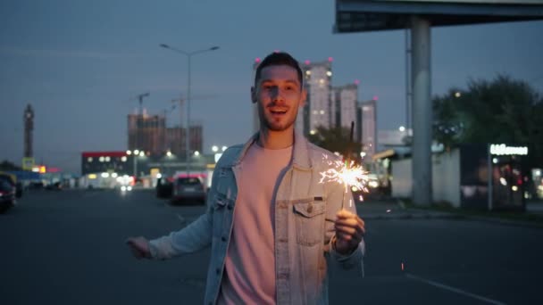 Retrato de chico guapo bailando en la calle de la ciudad sosteniendo la luz de bengala divirtiéndose — Vídeos de Stock