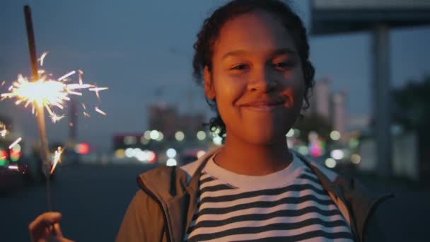 Portrait d'une jolie fille afro-américaine tenant la lumière du bengale à l'extérieur la nuit — Video