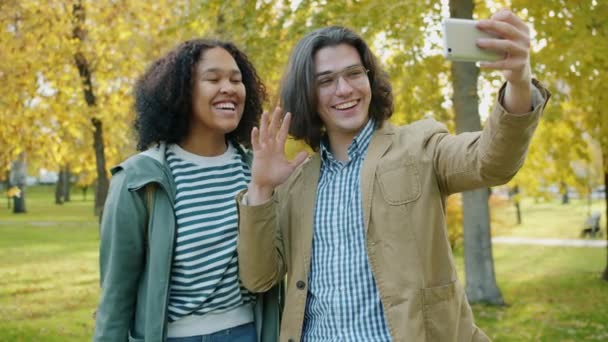 Boldog diákok barátok, hogy online video hívás okostelefon mutatja hüvelykujj-up — Stock videók