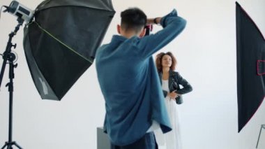 Modelci kadın ve fotoğrafçı fotoğraf çekimi sırasında stüdyoda çalışıyor.
