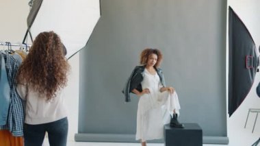 Model yavaş hareket ediyor. Stüdyoda stilist ve fotoğrafçıyla çalışıyor.