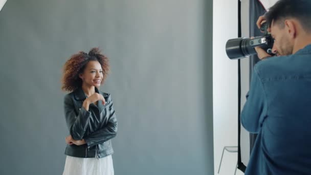 Vacker afro-amerikansk flicka poserar i studio arbetar med fotograf inomhus — Stockvideo