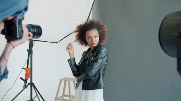 Mooi model in stijlvolle kleding poseren voor fotograaf met camera in studio — Stockvideo