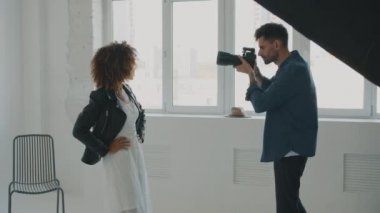 Modern stüdyoda profesyonel hotoshoot sırasında insanlar modellik ve fotoğrafçılık yapıyor.