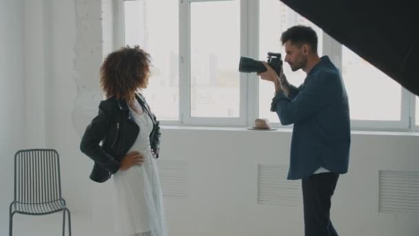 Люди модель і фотограф під час професійного гарячого пострілу в сучасній студії — стокове відео