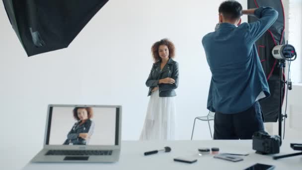 Dans les coulisses du studio photo : photographe prenant des photos de jolie femme métissée — Video