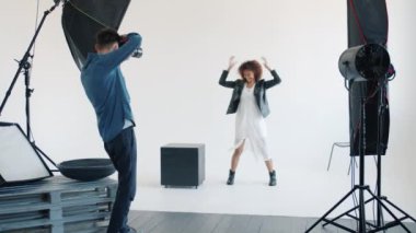 Neşeli Afro-Amerikan model atlama stüdyoda fotoğraf çekerken eğleniyor.