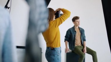 Modern stüdyoda kamera modelliği için poz veren yakışıklı adam modelinin yavaş çekimi.