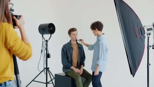 Modellarbete med sminkös sedan poserar för kameramodellering i studio — Stockvideo