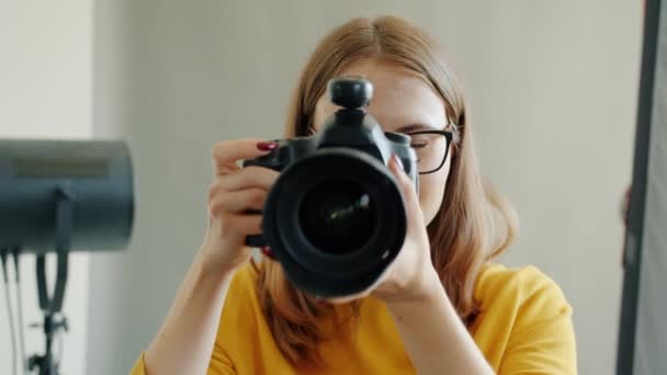 Portret uroczej fotograf dziewczyna robi zdjęcie następnie patrząc na aparat uśmiechnięty — Wideo stockowe