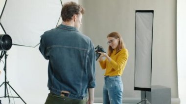Stüdyoda kamera kullanarak erkek modelin fotoğraflarını çeken yavaş çekim.
