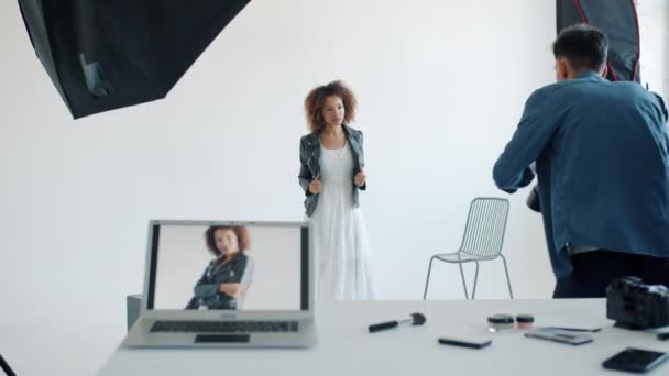 Hermosa joven posando para la cámara durante la sesión de fotos en el estudio con el fotógrafo — Vídeos de Stock