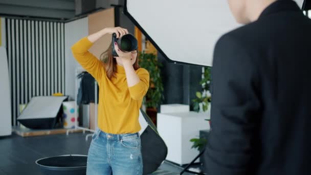 Professionell fotograf tar bilder av manlig modell med kamera i studio — Stockvideo