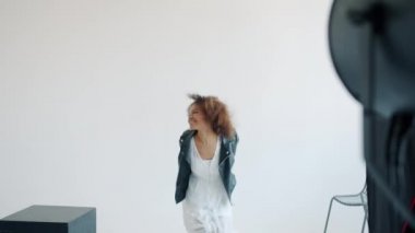 Güzel kız fotoğraf stüdyosunda eğleniyor. Profesyonel kameraya içeride poz veriyor.