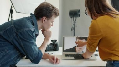 Model ve fotoğrafçının stüdyoda dizüstü bilgisayardan fotoğraf izlemesi