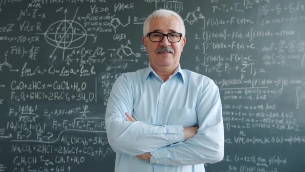 Confident college teacher standing in class with arms crossed looking at camera — Stock Video