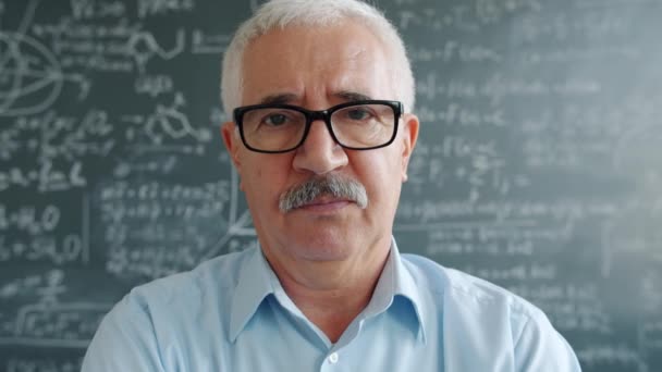 Portrait of smart man researcher standing indoors in class looking at camera — Stock Video