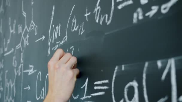 Gros plan des équations mathématiques de l'écriture manuelle masculine sur tableau en classe — Video