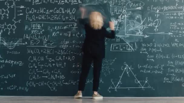Time lapse of smart lady professor writing formulas in classroom on board — Vídeo de stock