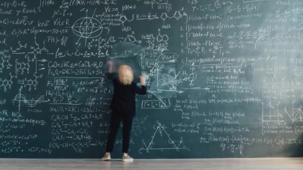 Time lapse back view of smart lady scientist writing formulas on chalkboard — Stock video