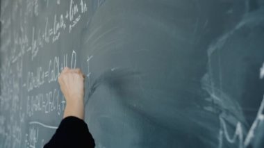 Karatahtaya kimyasal formüller yazan kadınların yavaş çekim yakın çekimi.