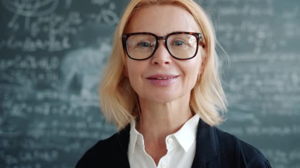 Portrait of attractive adult lady professor indoors in university class smiling at camera — Stockvideo