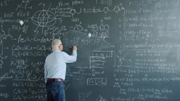 Professor escrever fórmulas a bordo, em seguida, sair enquanto os alunos jogando bolas de papel para ele — Vídeo de Stock