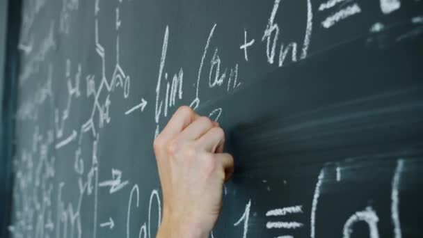 Close-up slow motion of maths student writing formulas on blackboard indoors — 图库视频影像