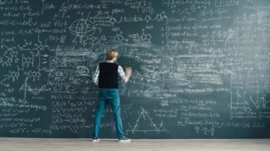 Time lapse of smart student writing formulas on blackboard working at scientific exercise