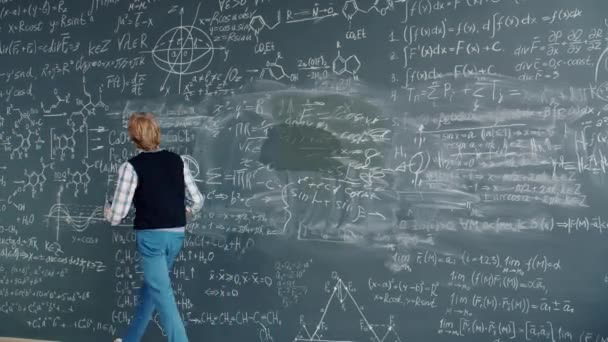 Time lapse of creative guy researcher writing formulas on chalkboard in class — Stockvideo