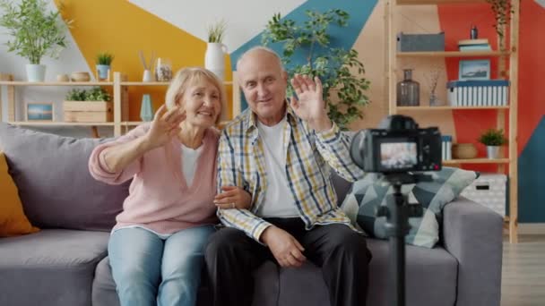 Personas mayores bloggers grabando video con cámara hablando de gestos en casa — Vídeo de stock