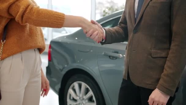 Mulher recebendo chaves do carro do vendedor, em seguida, apertando as mãos para celebrar o negócio bem sucedido — Vídeo de Stock