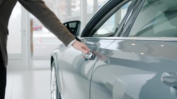 Close-up tiro de mão masculina abrir porta do carro em luxo auto concessionária olhando para dentro — Vídeo de Stock