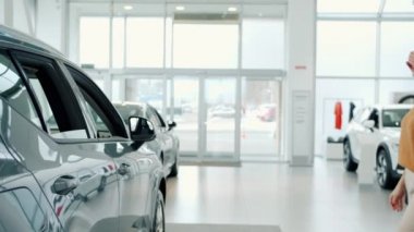 Businessman buying car for girlfriend making surprise happy lady hugging laughing