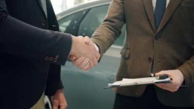 Close up of male hands getting car keys after deal with sales manager shaking hands