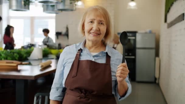 Retrato de senhora idosa vestindo avental sorrindo na aula de culinária desfrutando de educação — Vídeo de Stock