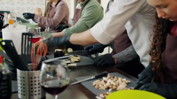 Hombres y mujeres jóvenes grupo de raza mixta cocinar alimentos durante la cocina master-class — Vídeos de Stock