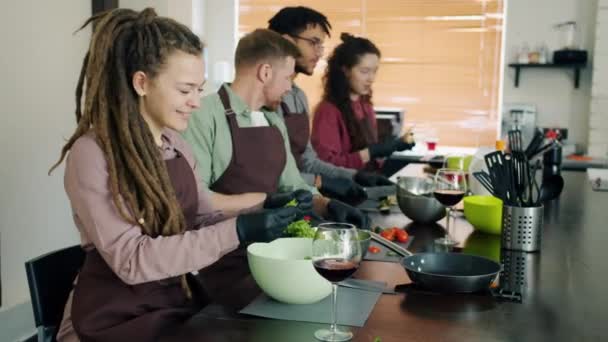 Giovani allegri gruppo multi-etnico cucina nella scuola di cucina indossando grembiuli — Video Stock