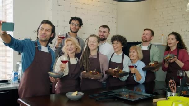 Étudiants des écoles culinaires prenant selfie avec appareil photo smartphone tenant des plats 