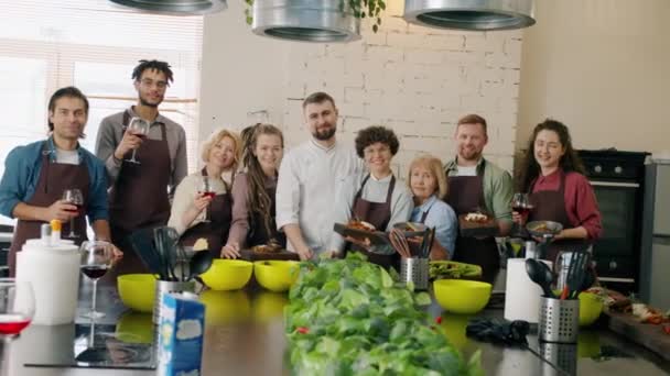 Портрет счастливых мужчин и женщин кулинарных школьников, улыбающихся, держа еду и напитки — стоковое видео
