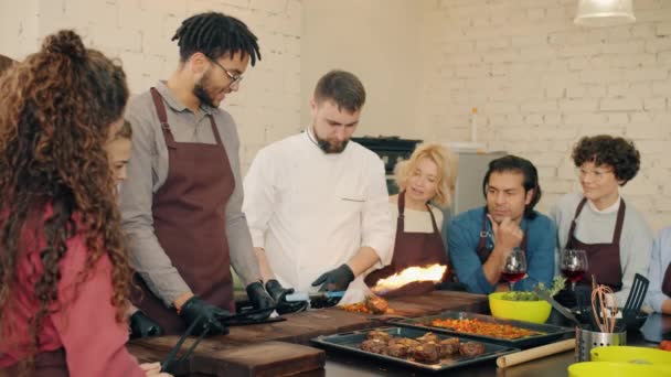 Langsom bevegelse av kokken som demonstrerer matlaging med ild under mesterklassen – stockvideo