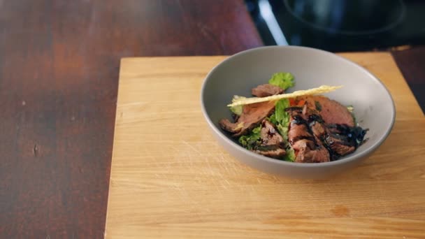 Närbild av läcker nykokt maträtt i skål på bord i kök — Stockvideo