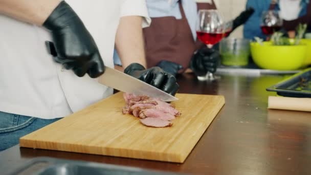 Långsam rörelse av manlig hand skära grillat nötkött gör kött skålen i köket — Stockvideo