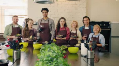 Yemek okulunda yemek ve içeceklerle dikilen çeşitli insanların portresi.
