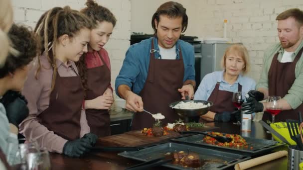 Радостные стажеры кулинарного класса готовят блюдо с огнем хлопая в ладоши, веселясь вместе — стоковое видео