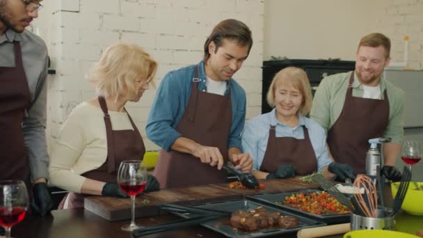 Groep studenten van de culinaire school koken maaltijd samen genieten van teamwork in de keuken — Stockvideo