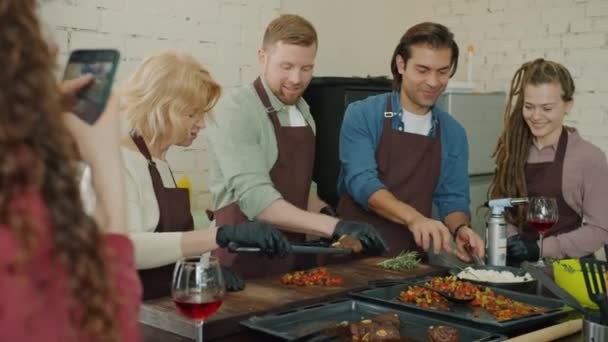 Groep koks maken maaltijd met vuur tijdens de kookles student het nemen van foto 's met smartphone — Stockvideo
