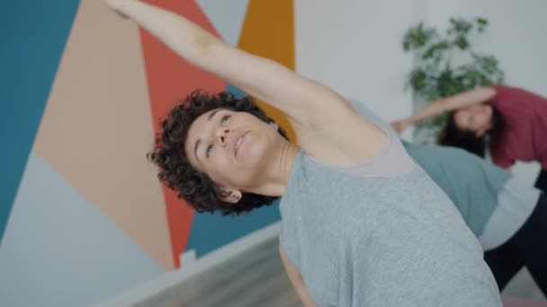 Vrouwelijke yoga instructeur onderwijs groep van studenten spreken tonen oefeningen — Stockvideo